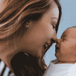 mujer sonríe a bebé día mundial de la sonrisa