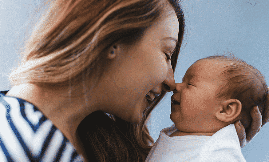 mujer sonríe a bebé día mundial de la sonrisa